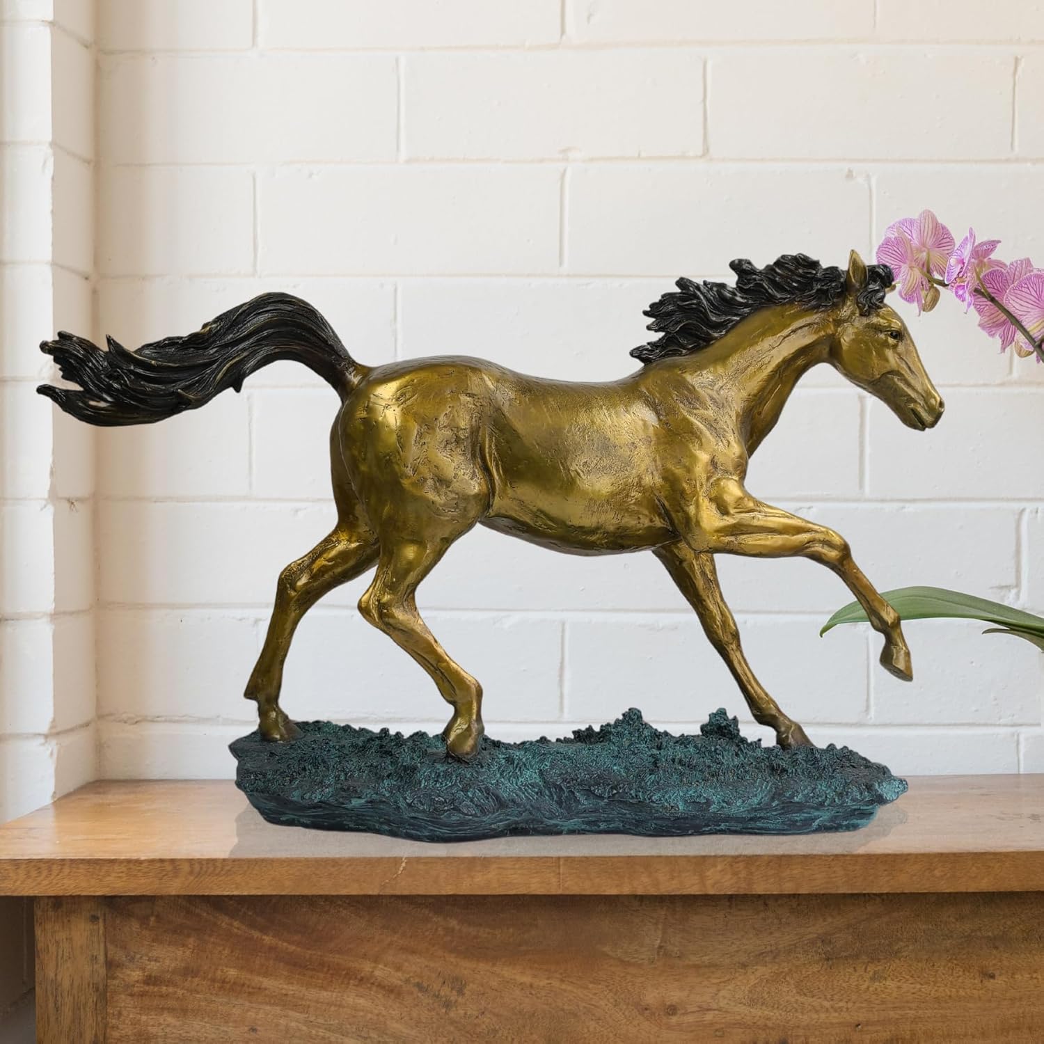 22-inch galloping bronze horse sculpture golden stallion with black mane displayed on wooden console with floral decor