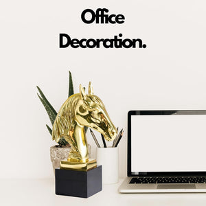Gold brass horse head statue displayed as office decoration on desk alongside laptop