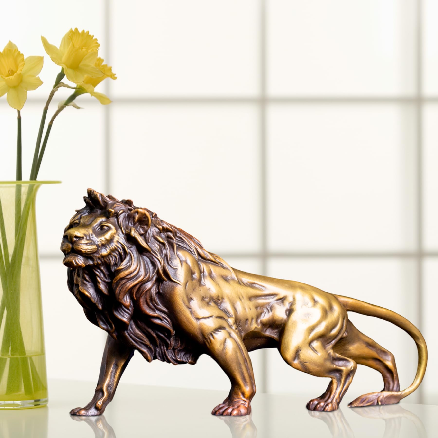 Gold bronze Lion King sculpture displayed alongside fresh flowers in bright indoor lifestyle setting
