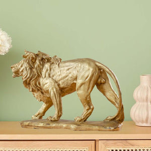 Gold bronze Lion King sculpture displayed against green wall in modern interior home decor setting