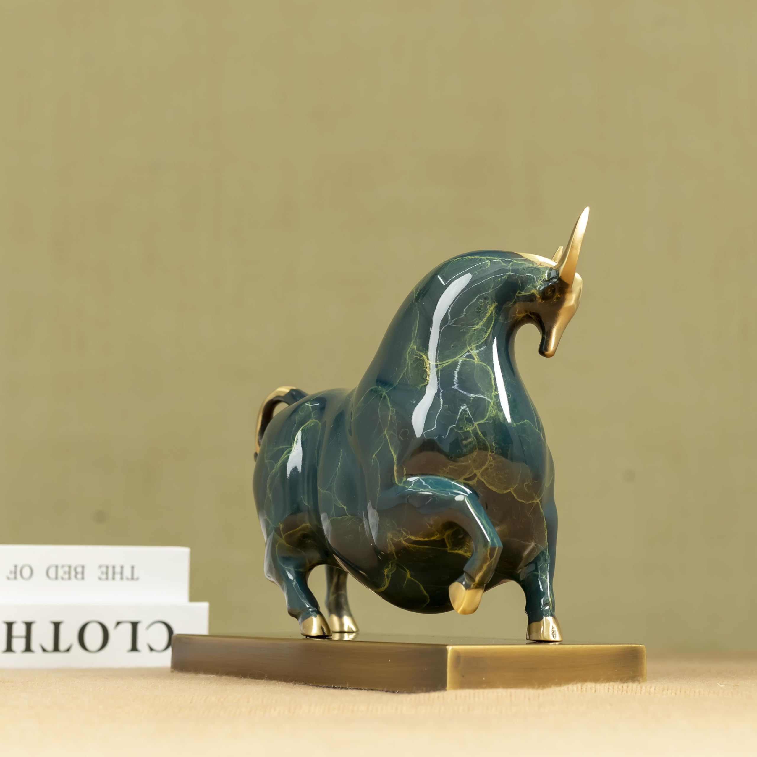 Close-up of green enamel bull head with golden horn finish.