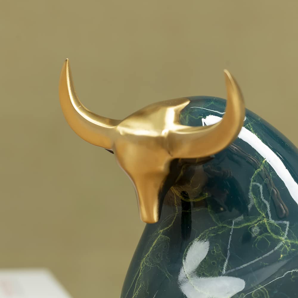 Detailed close-up of the polished golden horn on green bull.