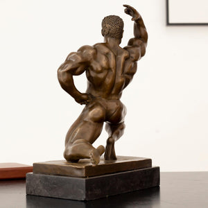 Left angle view of kneeling bodybuilder bronze statue showing full muscle definition and marble base