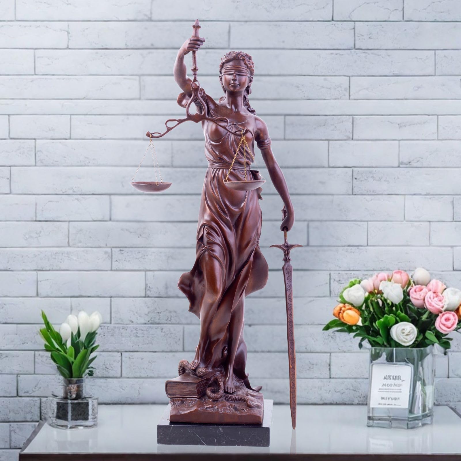 Large red bronze Lady Justice Themis statue displayed in outdoor garden setting front view