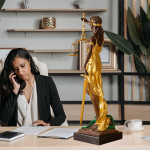 Large gold bronze Lady Justice Themis statue in female lawyer office while attorney on phone