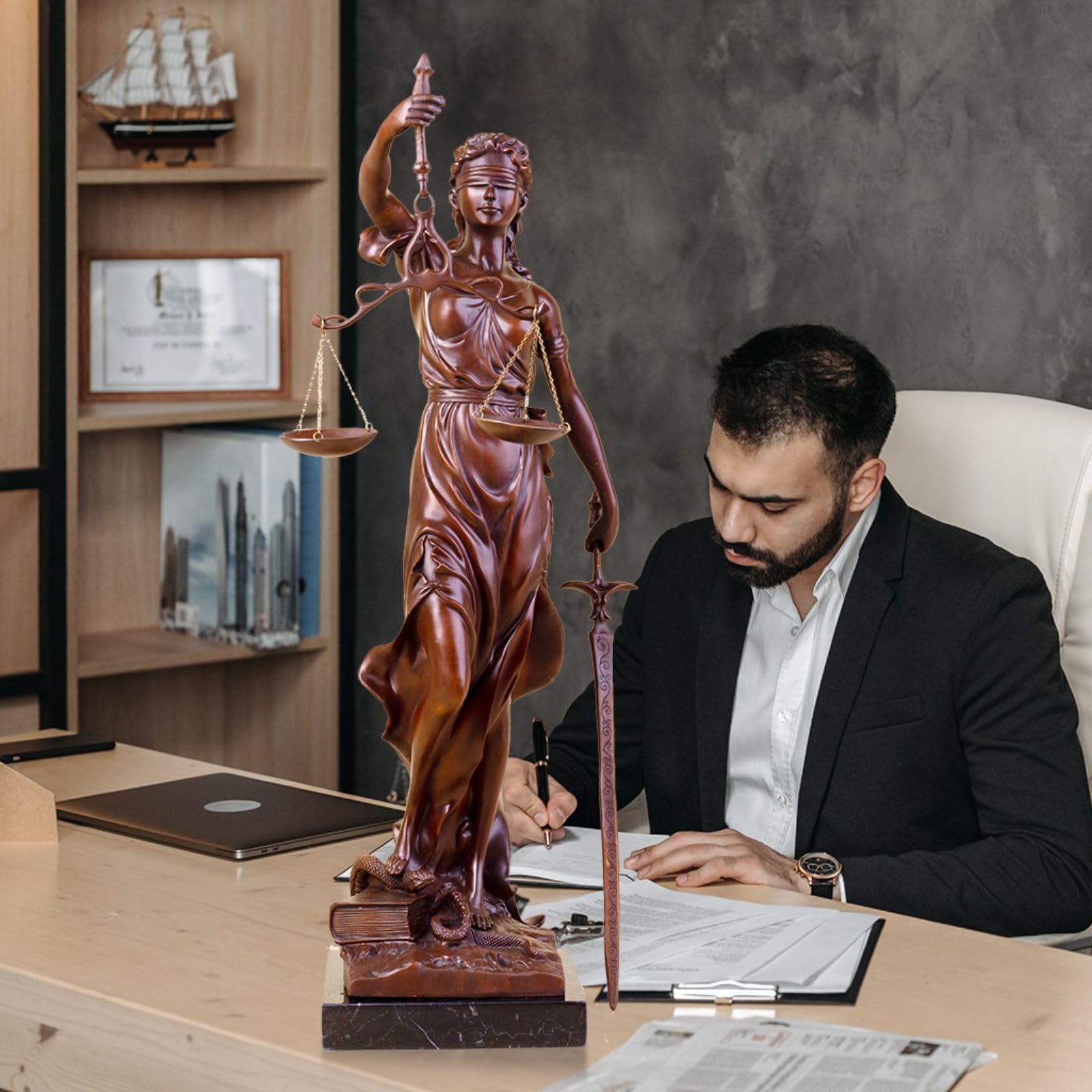 Large gold bronze Lady Justice Themis statue in male lawyer study office bookshelf setting
