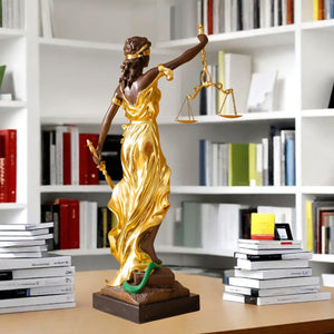 Large gold bronze Lady Justice Themis statue displayed on modern bookshelf in library setting