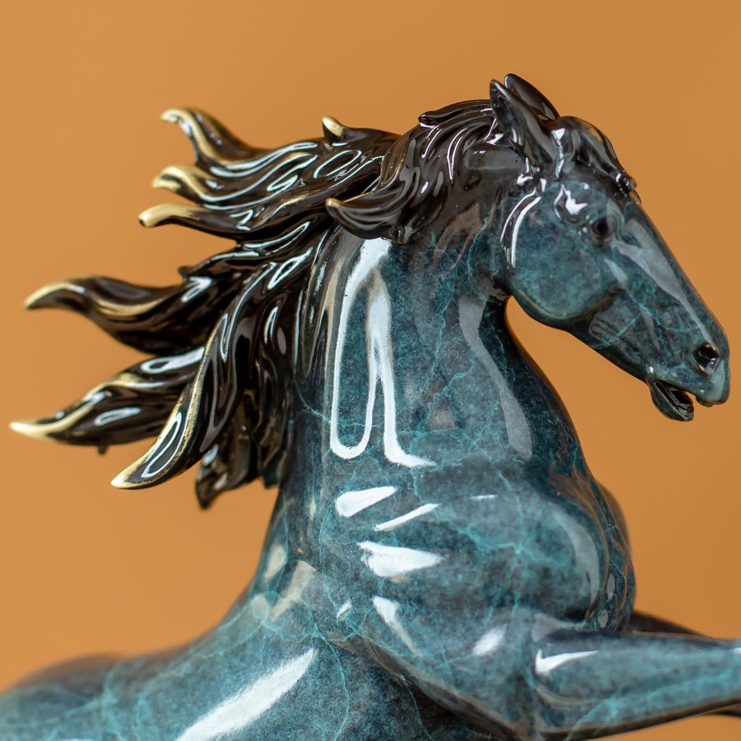 Close-up detail of azure blue rearing horse bronze sculpture head and mane texture