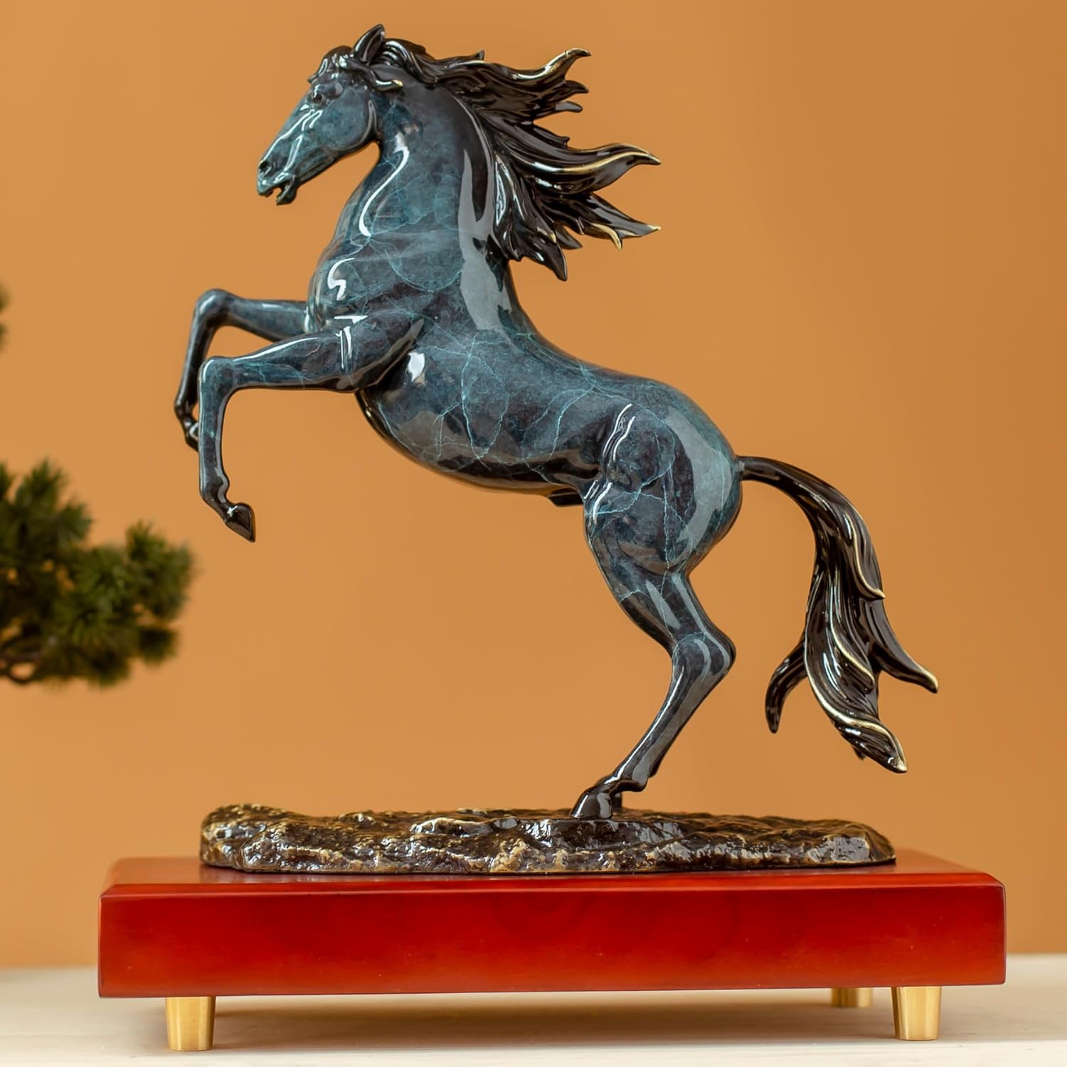 Azure blue rearing horse bronze sculpture side view on wood base with warm background