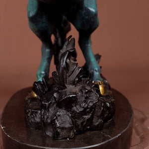 Close-up detail of azure blue bronze rearing stallion sculpture hooves and rock base with gold accent