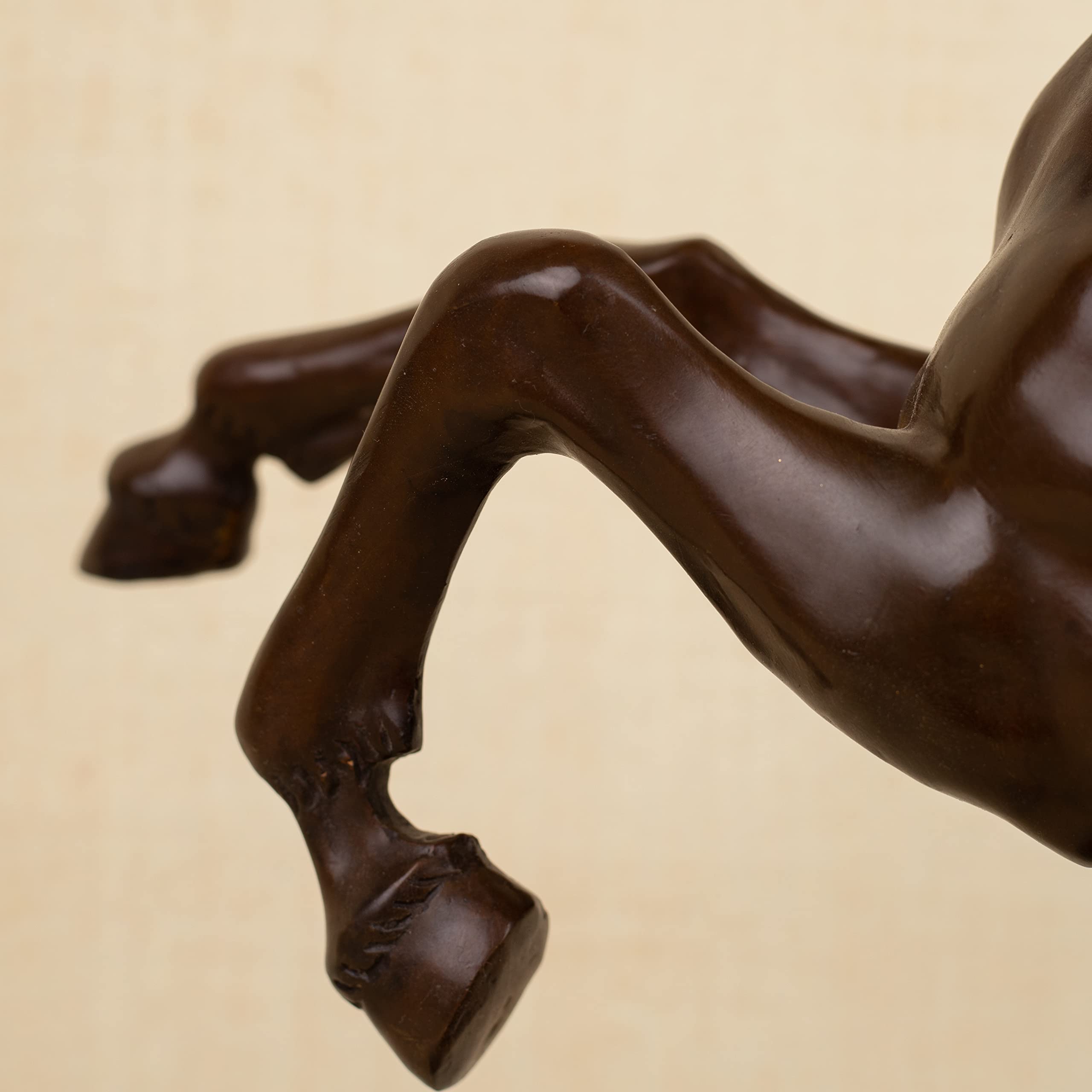 Close-up detail of bronze rearing stallion sculpture front leg and hoof showing rock base texture