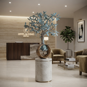 Large 1-meter bronze olive tree art sculpture showcased on a marble pedestal inside an upscale hotel or corporate lobby.