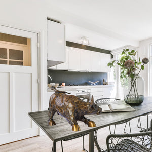 Patterned bronze charging bull statue used as modern financial office decor