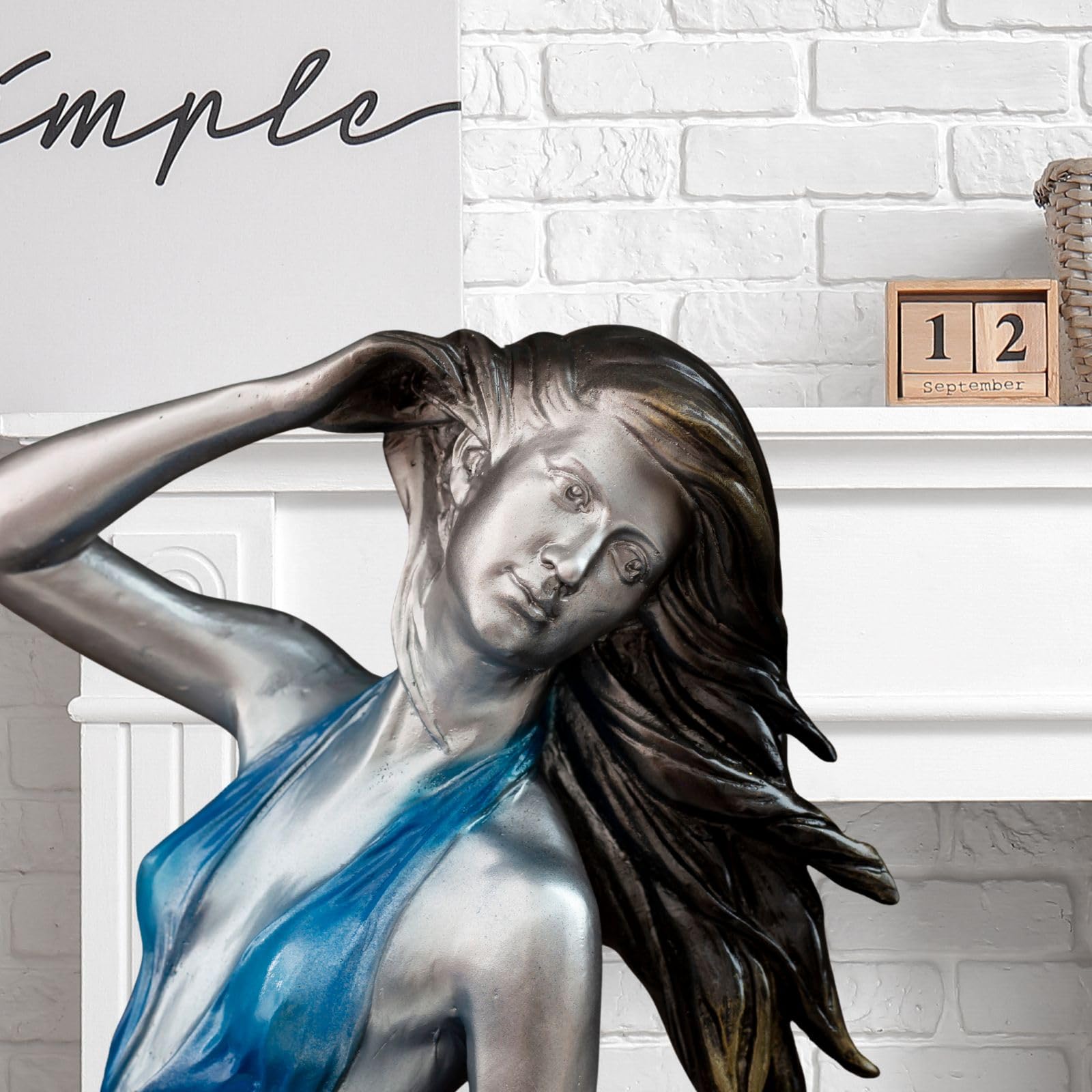 Neoclassical bronze wind dancer blue dress elegant pose ocean backdrop face detail