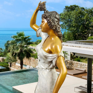 Pomona goddess bronze statue placed beside tree in courtyard showing polychrome finish and flowing gown