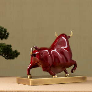 Red Wall Street bull sculpture displayed on executive office desk.