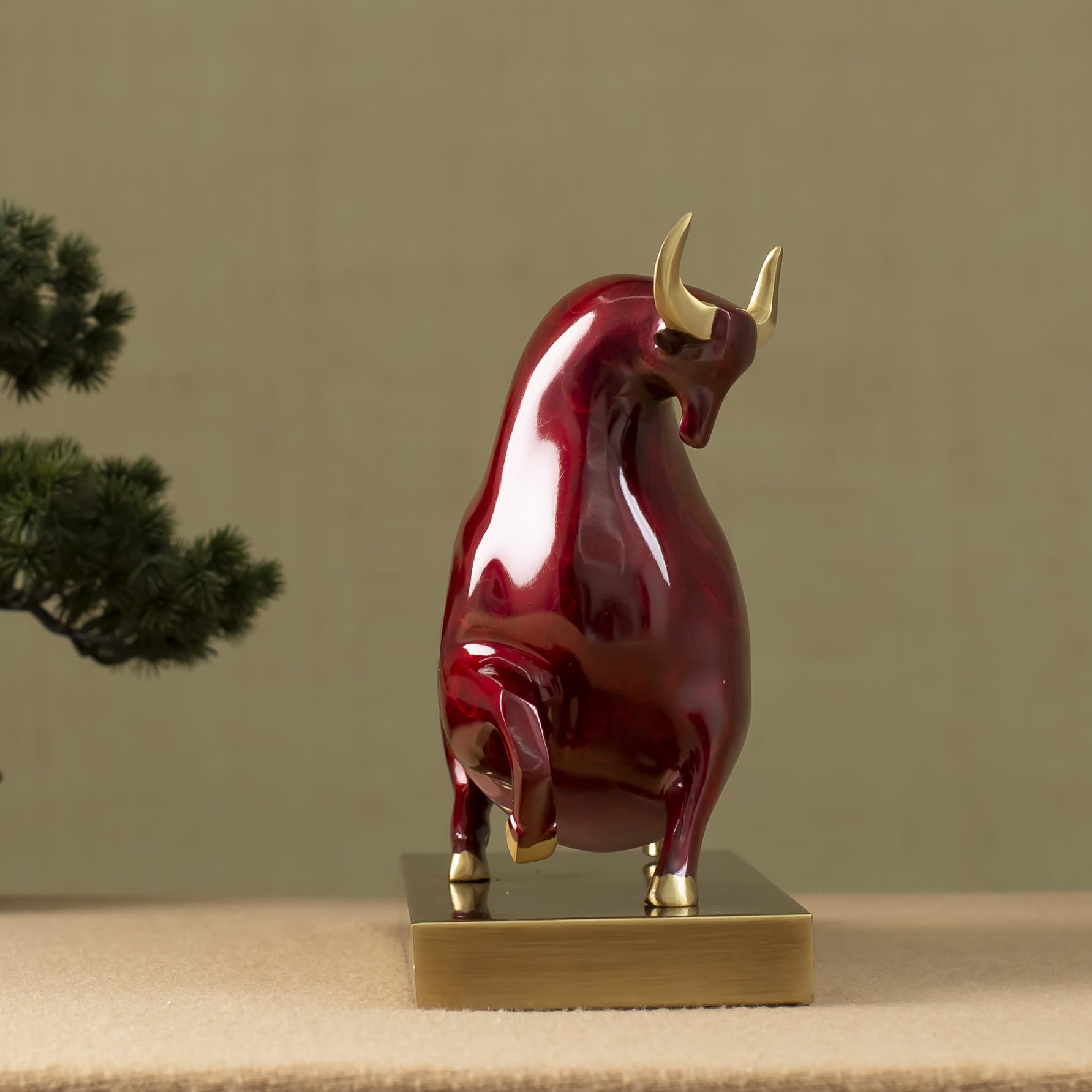 Close-up of red enamel bull head with golden horn finish.