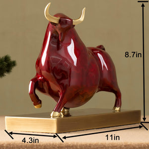 Profile view of the red enamel bull with polished brass base.