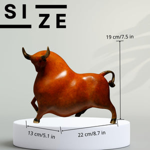 Profile view of the reddish-orange charging bull figurine.