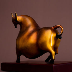 Reddish-orange bull art figurine styled on an office desk.