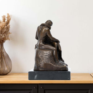 Rodin The Kiss bronze statue displayed on shelf beside indoor plant as home decor accent