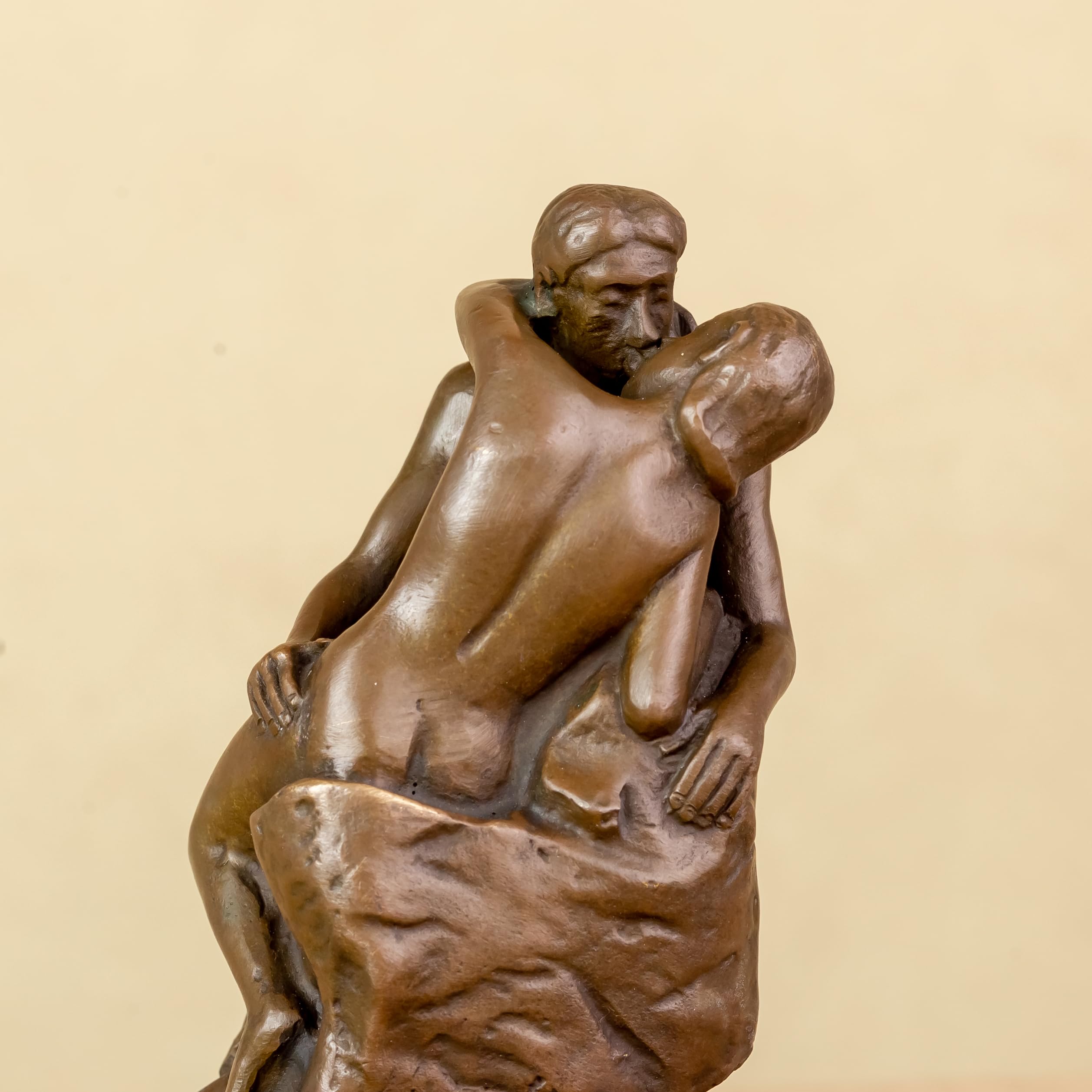 Rodin The Kiss bronze statue front view on warm beige background showing romantic couple sculpture