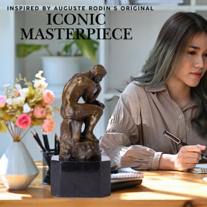 Rodin The Thinker bronze statue iconic masterpiece feature shown on desk beside woman writing