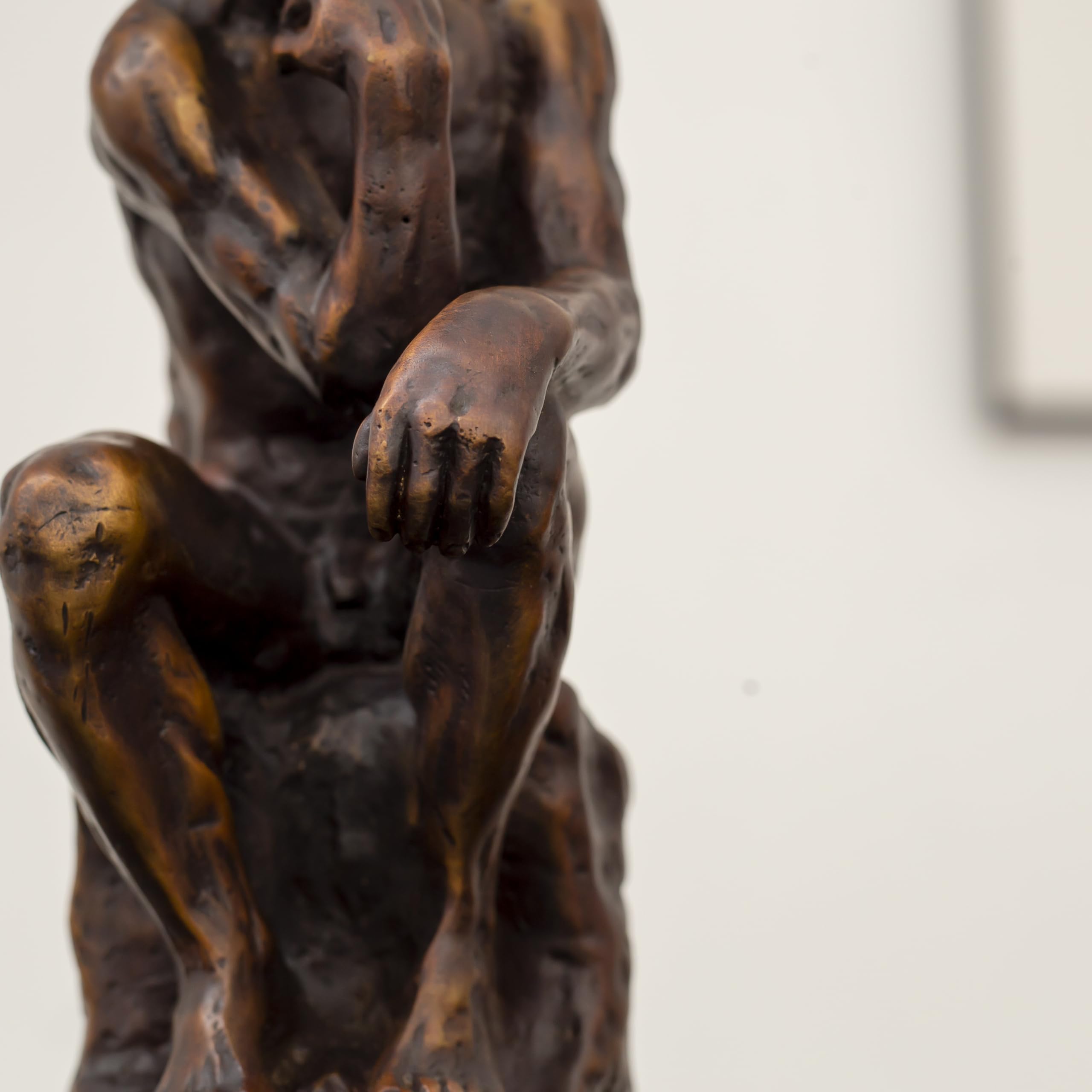 Close-up of Rodin The Thinker classical bronze statue showing detailed muscular figure and seated pose