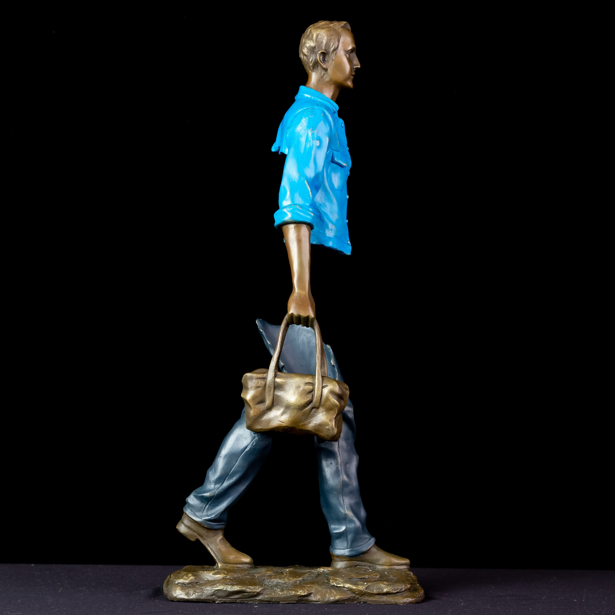 Detailed view of the hand-painted sage green bag on the sky light blue bronze traveler.