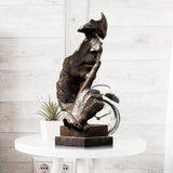 Silence is Gold abstract thinker bronze sculpture black patina displayed on white table with clock