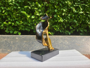 Side view of gold finish Silence is Gold thinker bronze sculpture on black marble base