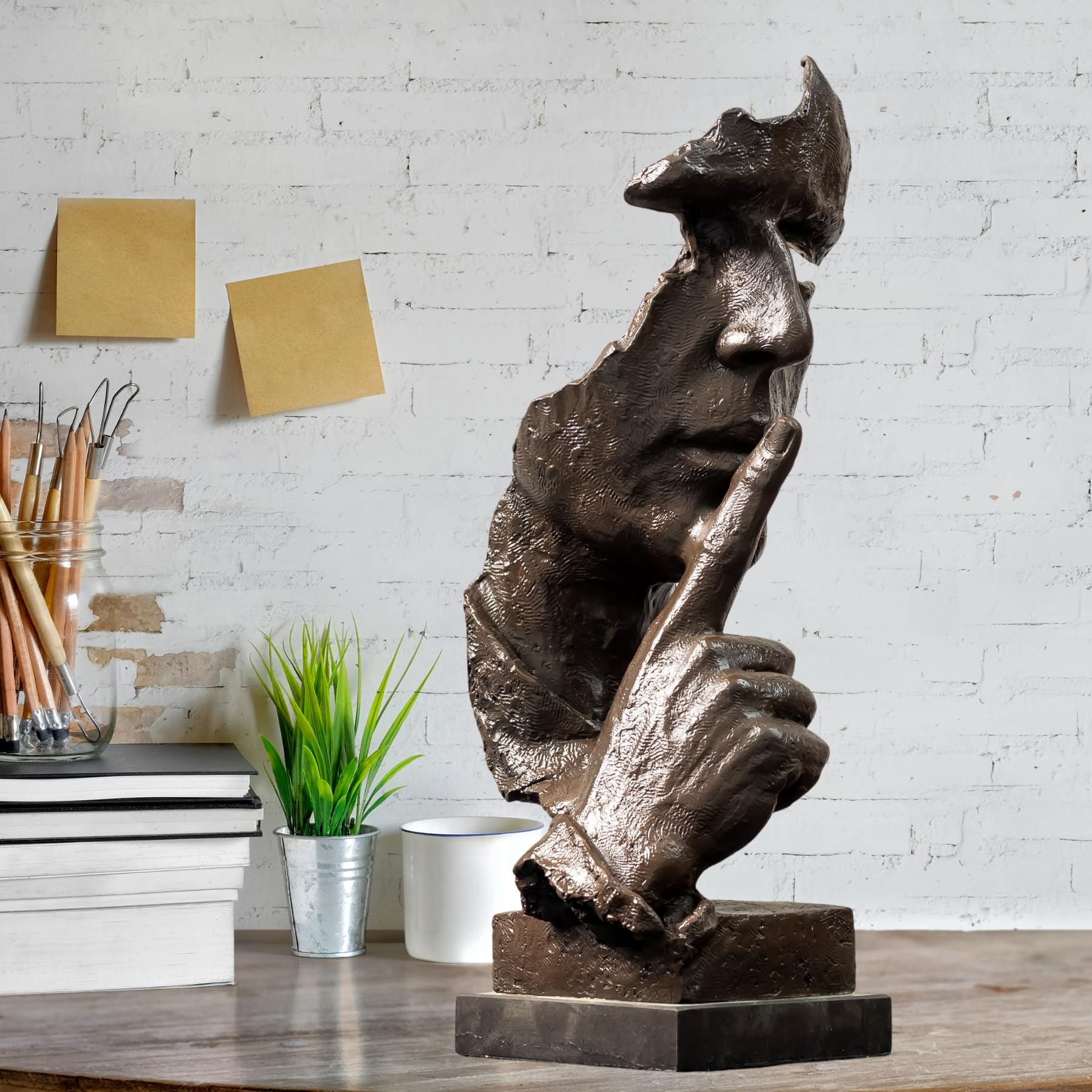 Side profile of black Silence is Gold abstract thinker bronze statue on marble base