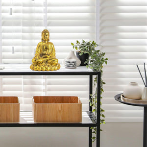 Brass Buddha statue lost-wax crafted piece displayed in bright modern living room interior
