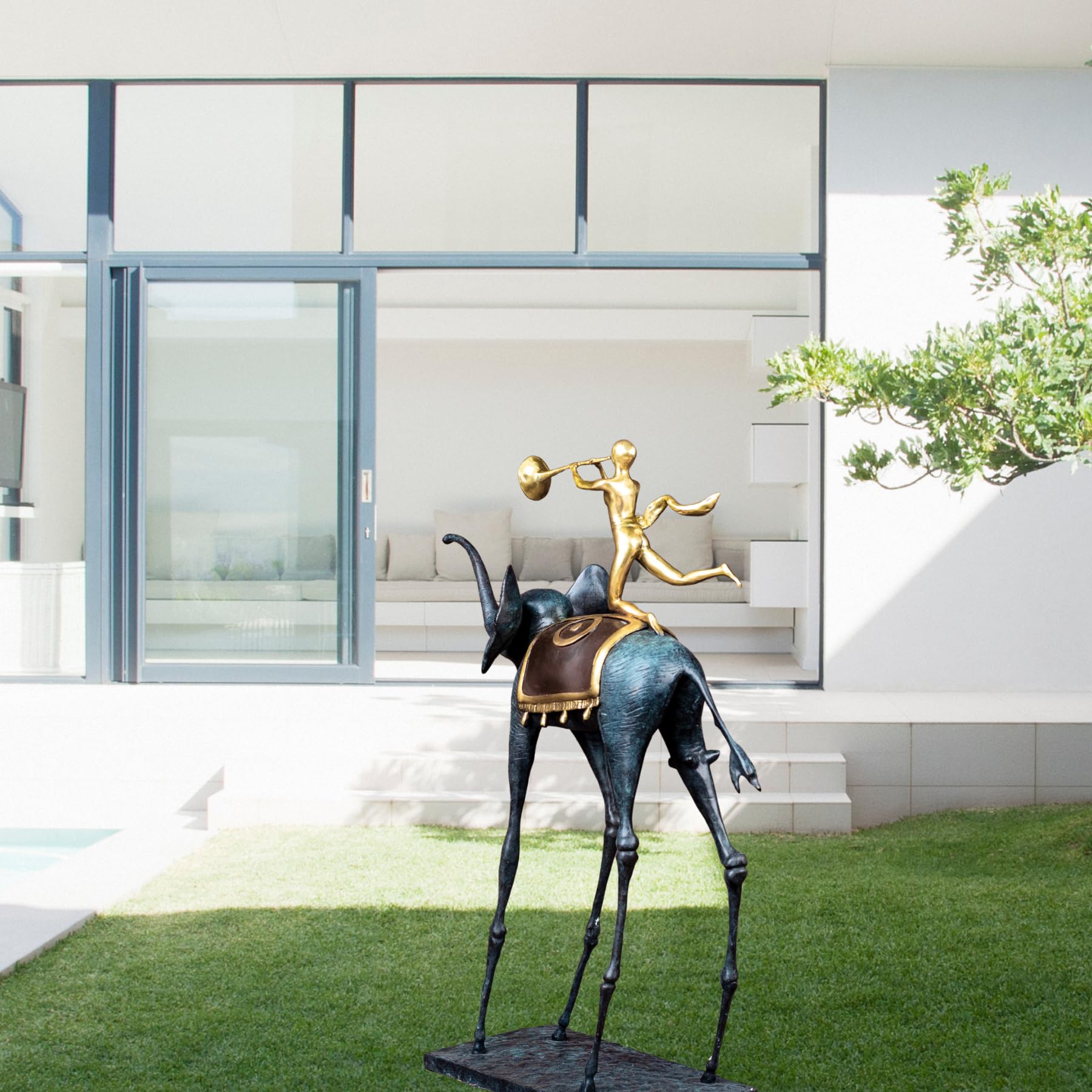 Surrealist bronze elephant statue displayed on garden lawn as outdoor abstract art sculpture