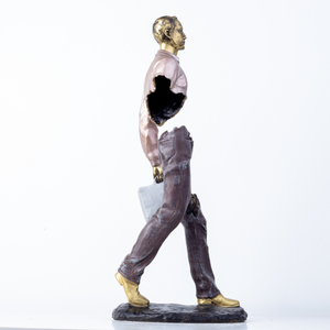 Side view profile of surrealist hollowed-out bronze traveler statue.