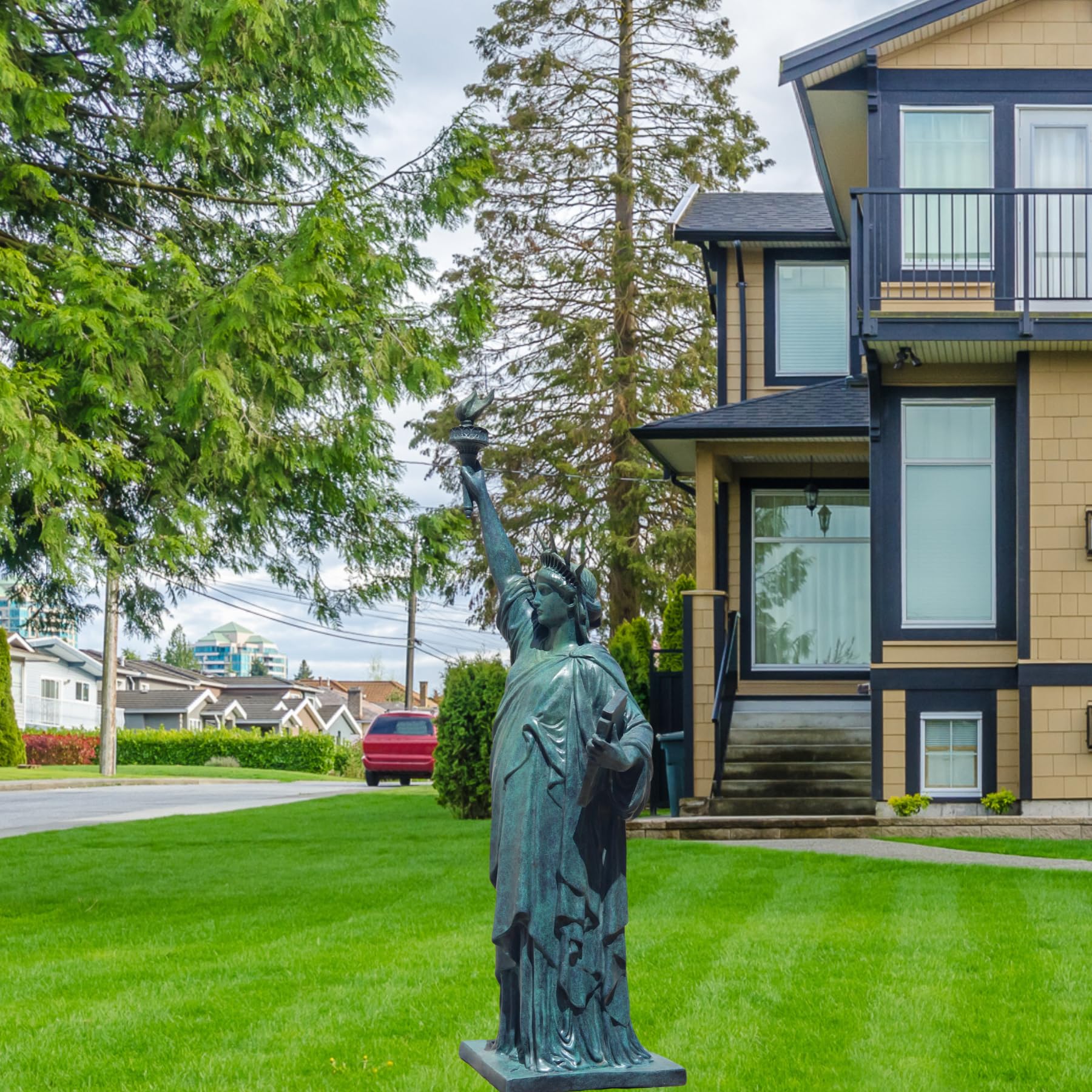 Verdigris blue bronze Statue of Liberty displayed on lawn garden in front of luxury house exterior