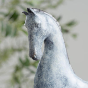 Close-up front detail of white bronze minimalist horse sculpture head showing textured surface finish