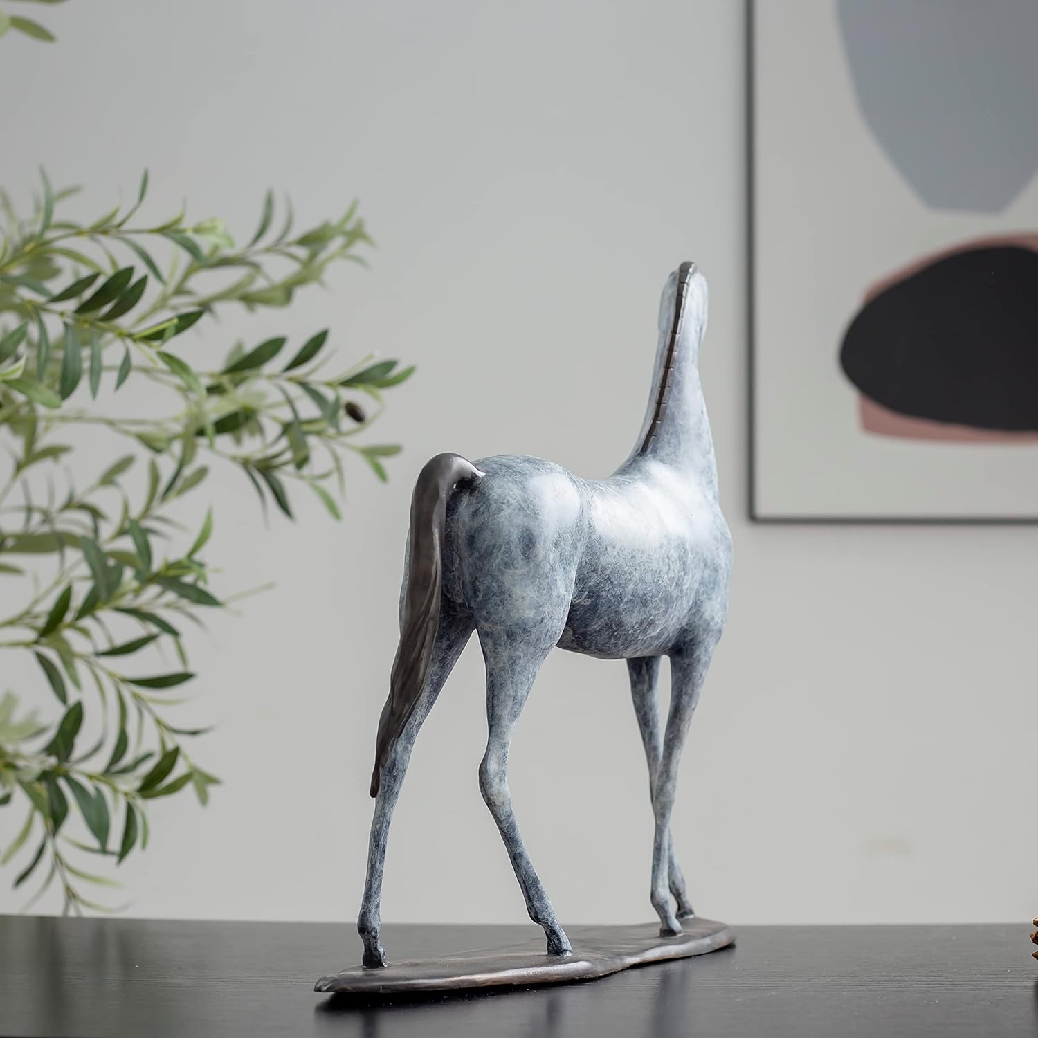 White bronze minimalist horse sculpture back angle view displayed in modern interior setting