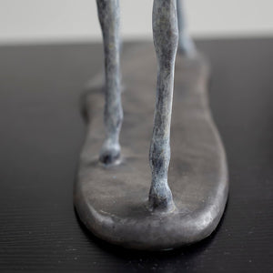 Close-up detail of white bronze minimalist horse sculpture legs and base showing sleek slender form