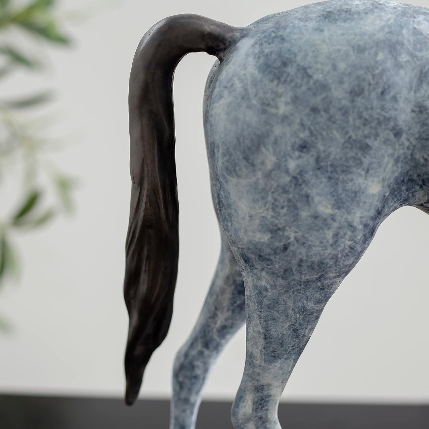 Close-up detail of white bronze minimalist horse sculpture tail showing flowing texture