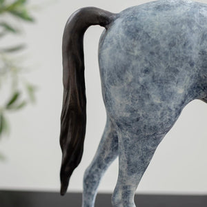 Close-up detail of white bronze minimalist horse sculpture tail showing flowing texture