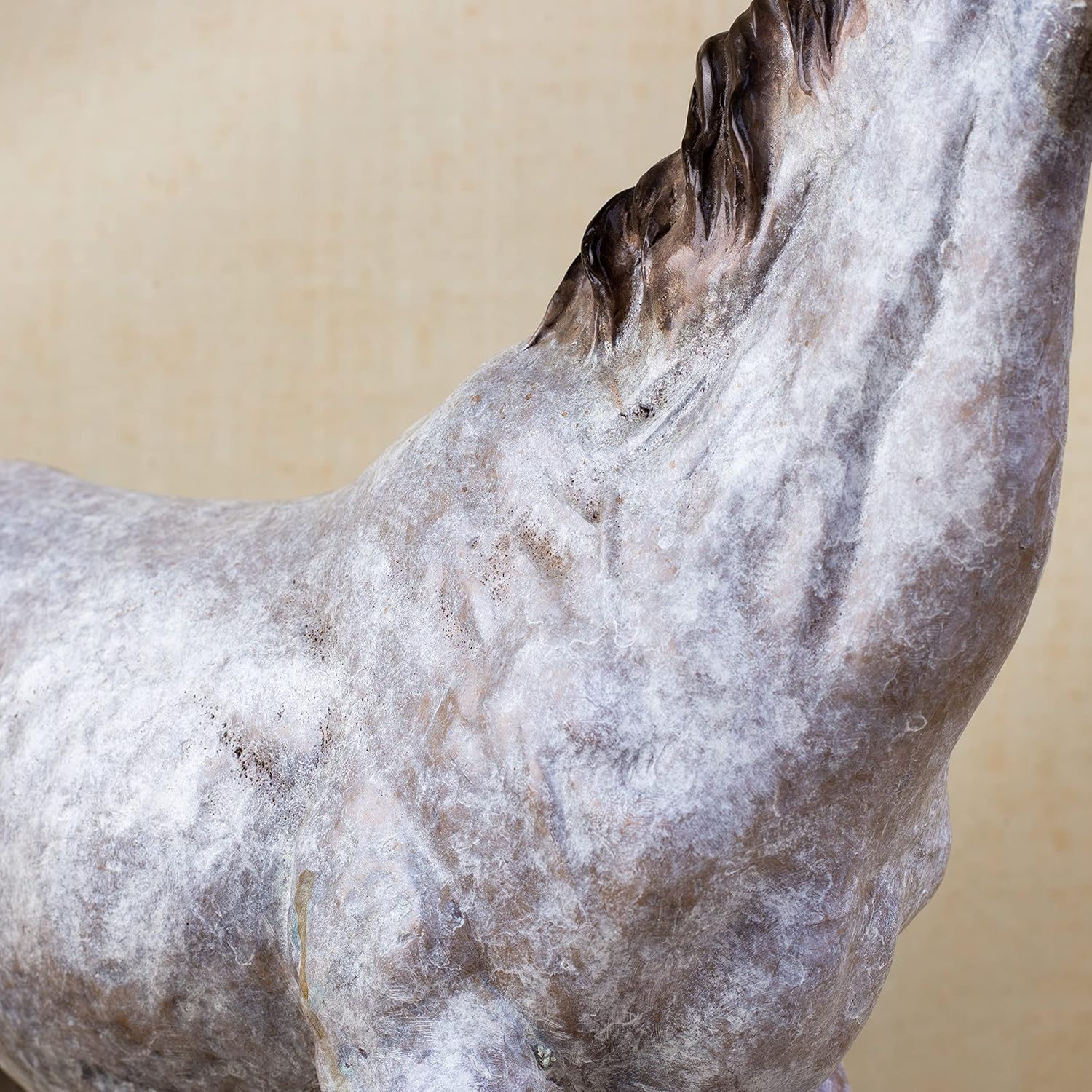 Close-up detail of white bronze horse sculpture back and mane showing dappled gray texture