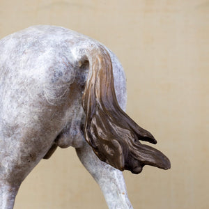 Close-up detail of white bronze horse sculpture tail showing flowing mane texture