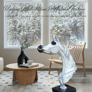 White patina bronze Arabian horse head sculpture displayed on coffee table in modern interior with vase decor