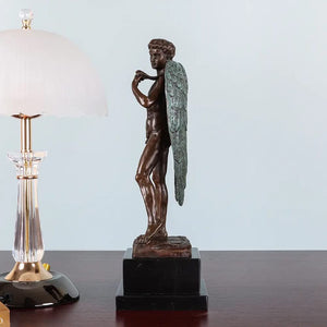 Left side view of winged David bronze sculpture on dark wood surface showing wing and body profile
