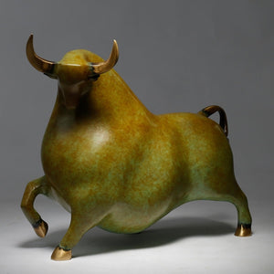 Yellowish-green bull sculpture styled on a professional office desk.