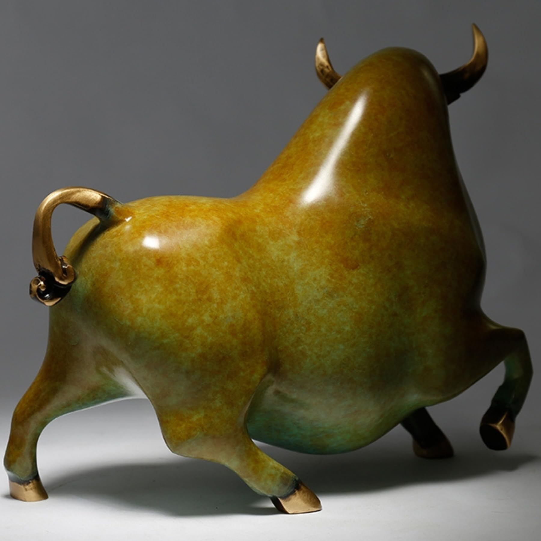 Polished brass hoof detail on the yellowish-green artistic bull.